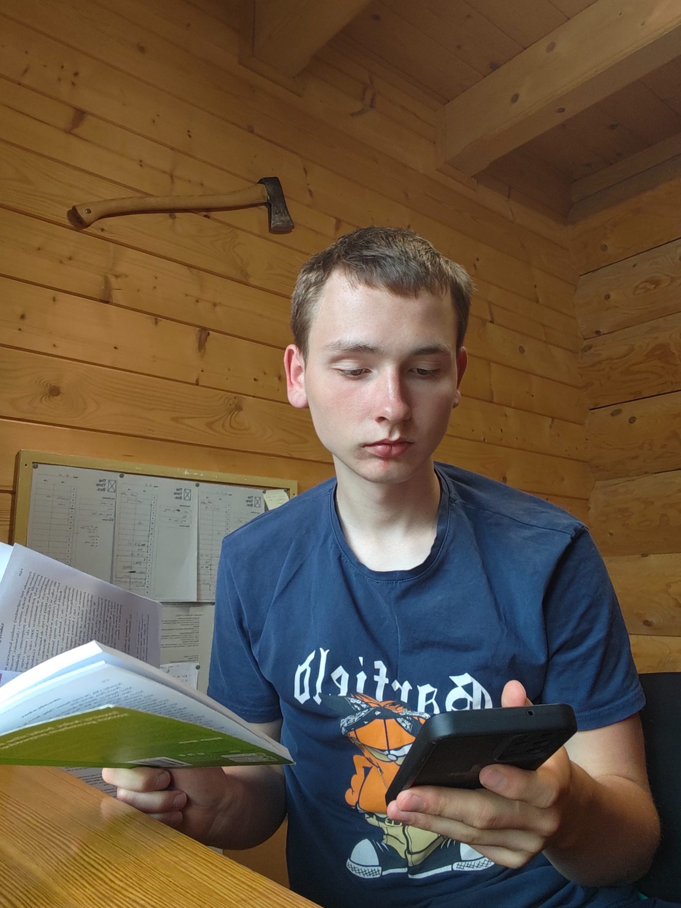 Reading a book with a phone in hand